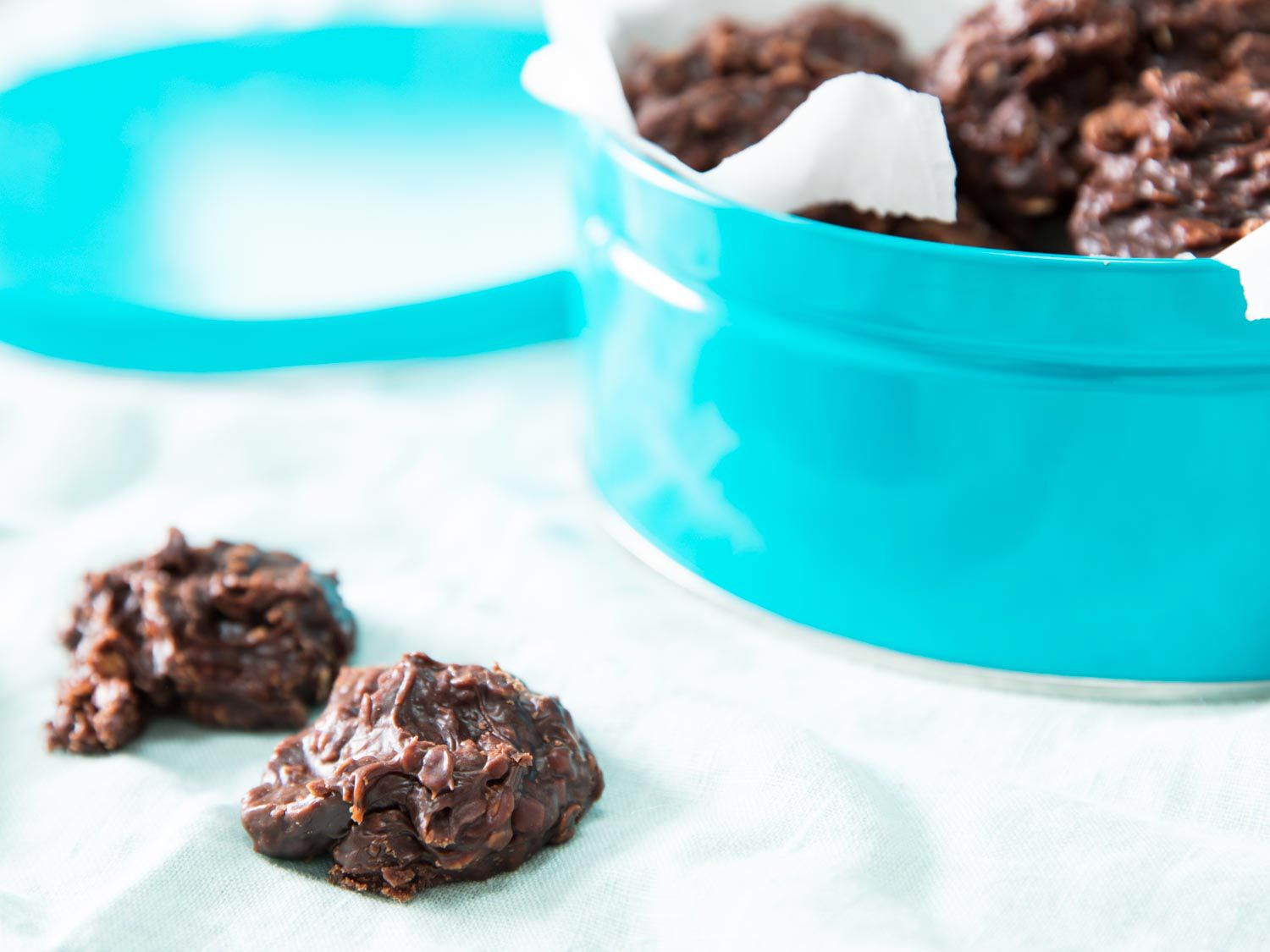 Chewy no-bake cookies next to a turquoise cookie tin.