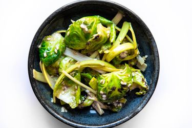 Overhead of bowl filled with pa-muchim salad made with Brussels sprouts and leeks.