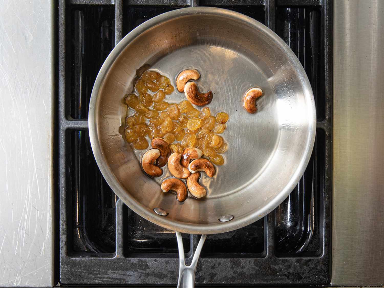 腰果和金色葡萄干在平底锅里煎