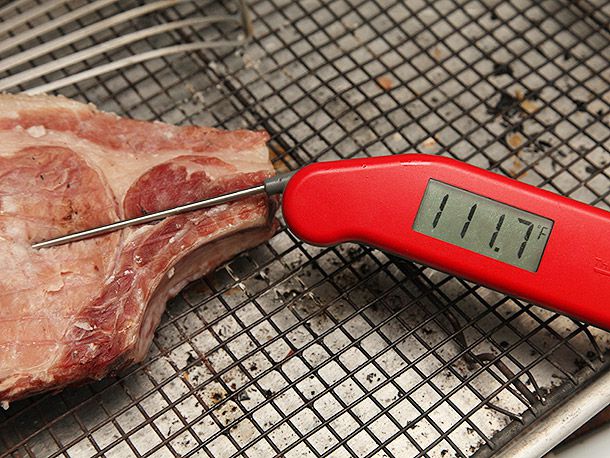 Instant read thermometer inserted in roasted pork chop, reading 111.7 degrees Fahrenheit.