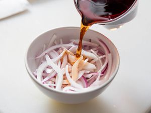 把醋倒在切好的红洋葱上，15分钟就能做出简单快速的腌洋葱。
