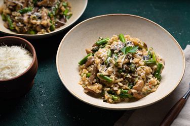 Mushroom and asparagus risotto plated in a shallow dish.