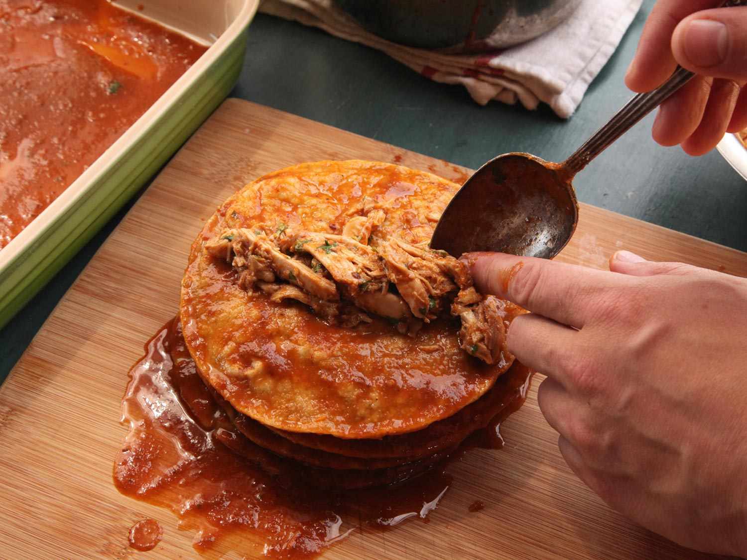 把鸡肉馅放在浸过酱汁的玉米饼中间。