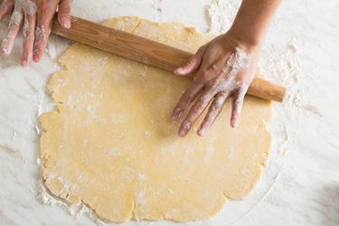 Rolling out easy, all-butter pie dough on a marble countertop.